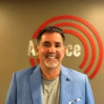 Bob Smith, VP of Security Operations and Sales at Alliance Security Team, smiling in front of the company logo.